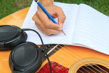 composer write note of song and use acoustic guitar for play
