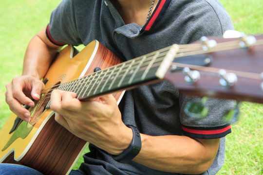 Musician playing guitar in the park