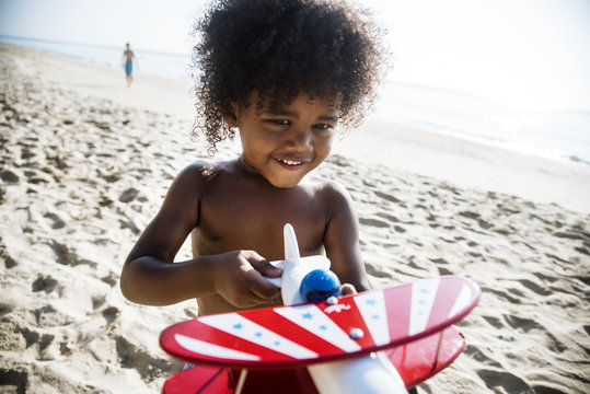 African little boy playing at the beach - Powered by Adobe