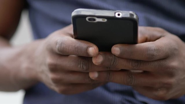 youth,technology, communication.black african man's hands typing on smartphone