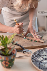 Artist cutting sheets of stained glass into small mosaic squares. Close-up