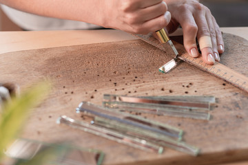 Artist cutting sheets of stained glass into small mosaic squares. Close-up
