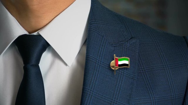 Businessman Walking Towards Camera With Country Flag Pin - United Arab Emirates