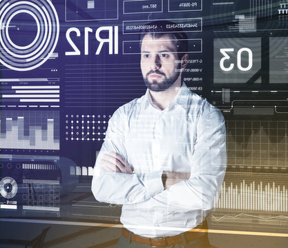 Calm Man. Serious Attentive Computer System Analyst Standing With His Arms Crossed And Looking At The Information On The Screen Of His Futuristic Transparent Computer