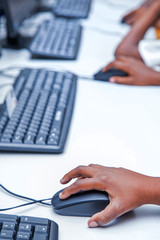 Childs hand on mouse button,  learning how to go on internet in classroom.