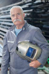 portrait of older male steel worker welding with protective mask - obrazy, fototapety, plakaty