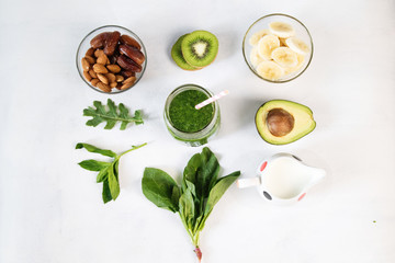 Glass of green vegetable smoothie on white background from top view