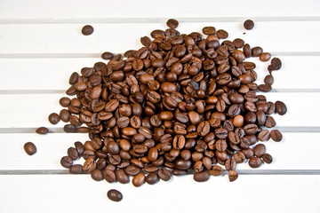 Grains of coffee lie on a white table