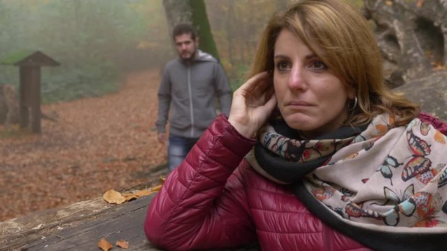 man apologizes to his angry sad girlfriend- outdoor