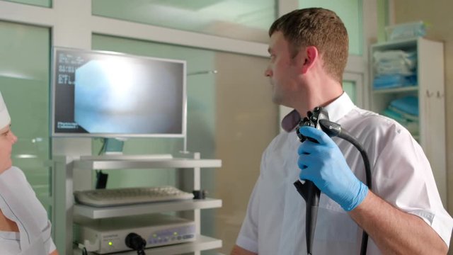 The doctor and the nurse do a colonoscopy through the mouth of the patient