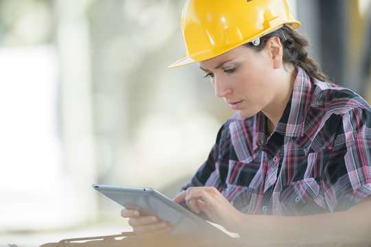 emale construction worker reading something on tablet computer