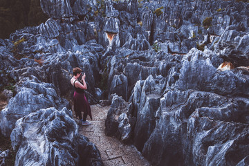 Fototapeta na wymiar Woman tourist in stone forest, rock formations in Yunnan, China