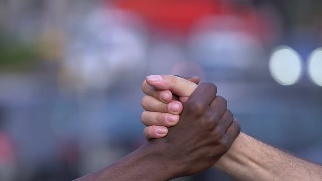 solidarity, equality, brotherhood.hands of a white man and a black man greeting