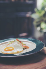 Zucchini fritters with egg and smoked salmon on wood background vinage style