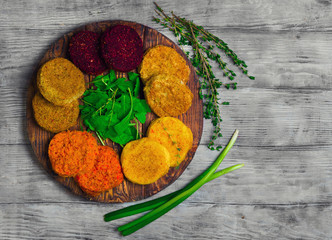 Vegetables patties (cutlets) for vegan burgers in bowl. Mix Vegetables stack fresh burgers. Spices for patties (cutlets) thyme, arugula. Gray wooden background. Top view