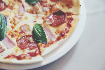 pepperoni bacon and ham pizza in restaurant background
