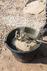 The worker mixes the concrete mixture at the construction site