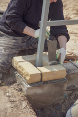 The worker lays bricks on the construction site
