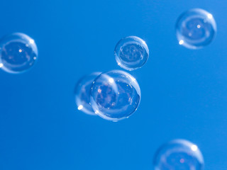 Soap bubbles in flight against the blue sky