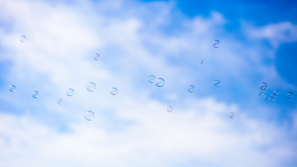 Soap bubbles in flight against the blue sky