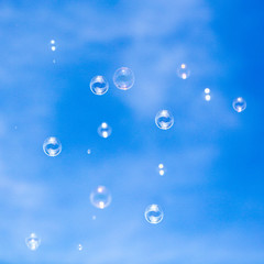 Soap bubbles in flight against the blue sky