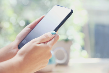 Close up on woman hand holding smartphone trading stock and data in coffee shop background business concept