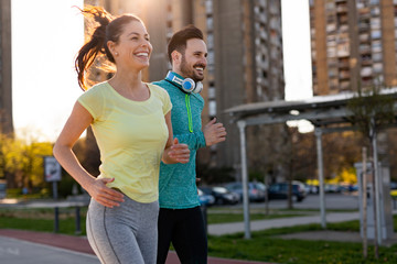Young fitness couple running in urban area