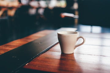 Cloase up coffee cup on wooden table in coffee shop.