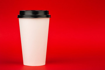 white paper Cup with a lid. Cup for coffee on red background.