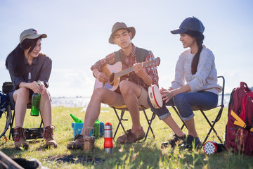 Happy group young friends in camping tent party having playing music fun together