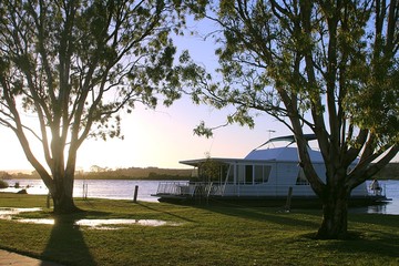 Evening at the Murray River in Australia with houseboat anchored to the shore