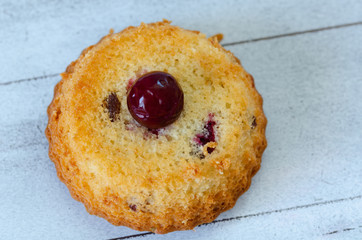 Fresh sponge cake with cherries on rustic wooden background