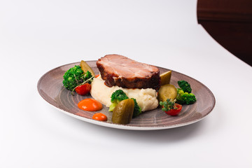 Front and top view isolated - The slow cook recipe with chilli pepper, mashed potatoes, broccoli and pickled cucumber.