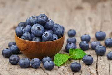Blueberries in a wood bowl on a wooden table, Healthy eating and nutrition concept
