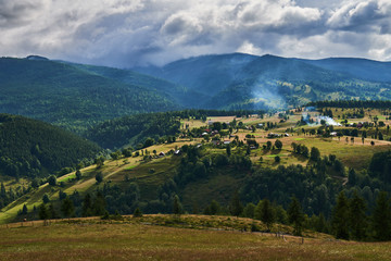 Naklejka na ściany i meble Mountains with forests and village