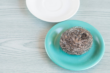 Steel wool with dish on wood table ,cleanning tool.