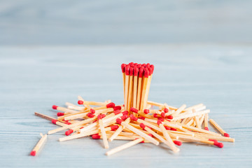Matchstick out of matchbox on color wood table.