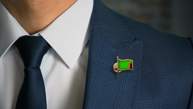 Businessman Walking Towards Camera With Country Flag Pin - Zambia