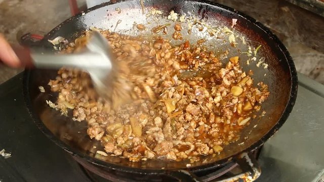 Frying minced pork with herb in pan