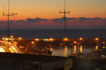 Night embankment and bay in Heraklion with night illumination and sunset (Greece)