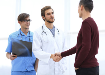 smiling doctor shaking hand of a patient