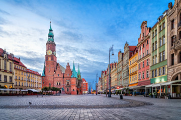 Fototapeta premium Kolorowe domy i zabytkowy budynek ratusza na placu Rynek o zmierzchu we Wrocławiu