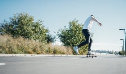Young attractive man riding longboard.