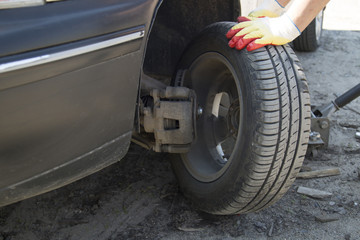 Mechanic changing wheel on car with impact wrench , Mechanic changing car wheel in auto repair shop , Close up of mechanic changing wheel on car with pneumatic wrench