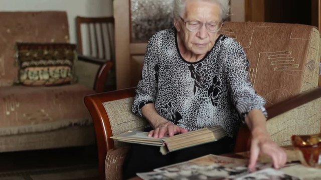 Very Old Woman Looking At A Photo In Old Photo Album, Memories