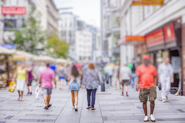 Crowd of anonymous people walking on busy city street