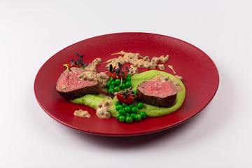 Front and Top View Isolated - Beef steak, peas, green pepper sauce.