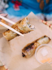 Vietnamese cuisine Nem Ran spring roll on plate with chopsticks in hand