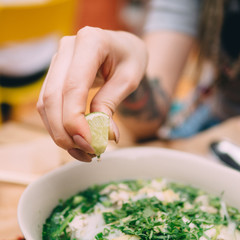 Vietnamese cuisine soup Pho Ga with chicken, noodles, fresh herbs and sauce in a bowl