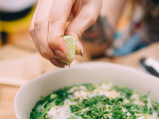 Vietnamese cuisine soup Pho Ga with chicken, noodles, fresh herbs and sauce in a bowl